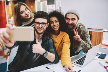 Ön kameraya poz ve komik selfies smartphone üzerinde beyin fırtınası sırasında yapmak mutlu kadın ve erkek öğrenciler. Çekim telefonla sonra başarılı işbirliği çeşitlilik tasarımcılar ekibi