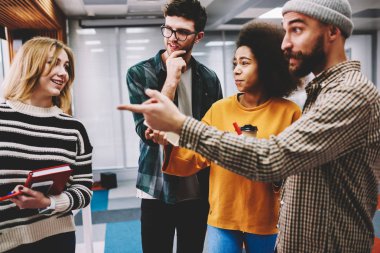 Genç şık profesyonel ekip işbirliği içinde modern ofis sırasında fikirleri tartışmak grafik tasarımcıları kırpılmış görüntü. Yetenekli hipster çocuklar birlikte başlangıç planlama sırasında beyin fırtınası