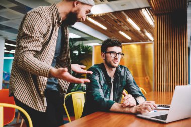 Genç kırpılmış görüntü sürpriz grafik tasarımcı ve durulması meslektaşım alan coworking içinde vakit fikirleri tartışmak sakallı. Yetenekli hipster çocuklar birlikte dizüstü kullanarak office birlikte çalışma