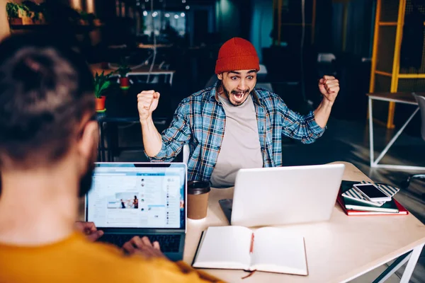 Çok memnun erkek futbol fan takım izlerken maç çığlık zaferi ile hayrete ve çalışma sürecinde duygusal hipster adam kazanma contes içinde harika bir haber kutlama eller yükselterek neşelen