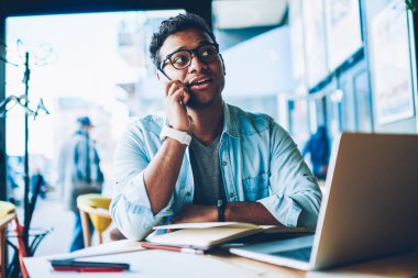 Olgun yakışıklı olumlu hindu girişimci havalı gözlükler müşteri yolu ile wifi için bağlı Smartphone uygulama ile iletişim içinde. Cep telefonu kapalı arkadaşlarınızla konuşurken iyi görünümlü adam