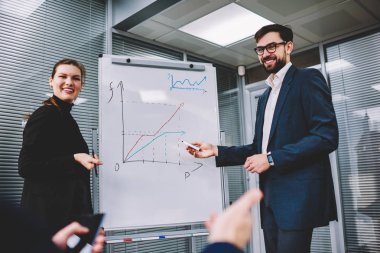 Akıllı Yardımcısı veren sunum toplantı, insanlar neden harika bir fikir gösteren flip grafik grafikler üzerinde yararları açıklayan yeni ofis hakkında konuşurken meslektaşları ile güzel iş kadını