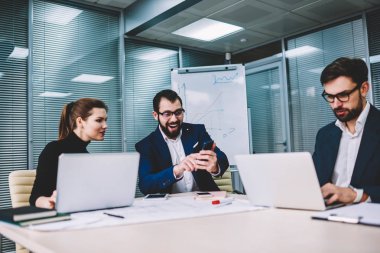 Grup çalışma office elektronik cihazlar ile iş adamları smartphone üzerinde proje ile ilgili iyi haber alma çok memnun erkek meslektaşı başarı zaferini kutluyor uzmanlar ekip