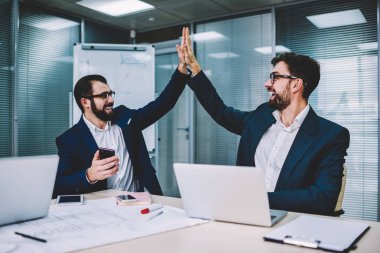 Erkek tasarımcılar ilk proje hazırlandı ve her diğer beş yüksek veren işadamı ile onların yeni ofisinde oturan toplantı üzerinde anlaşma memnun ve mutlu hissediyorum birlikte, başarı hakkında heyecanlı