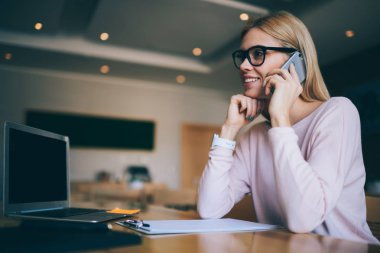 Büyüleyici ve çalışmak için en iyi arkadaşı, modern dizüstü bilgisayar ve masada kalan kağıtları cep telefonu iletişim Üniversitesi'nde sınıfta hippi kız 20 yaşında oturma gülümseyen