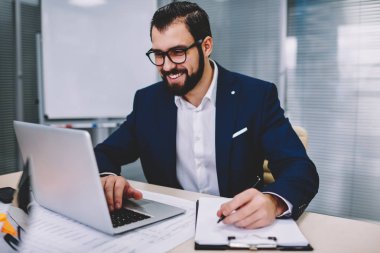 Kablosuz 4 g internet yazarken notlar için aşağı üretken çalışma ofisinde oturan müreffeh sakallı girişimci iş webinar online web sitesinde dizüstü bilgisayar izlerken bağlı