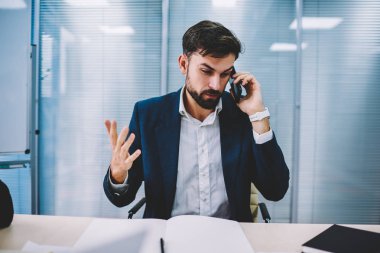 Öfkeli işadamı el eller ve smartphone için işlecini çağırmak çözme bankacılık sorunu. Telefon görüşmesi sırasında cep üzerinde çalışma sırasında office savunarak kızgın icra müdürü