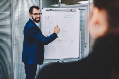 Arkadan görünüşü kadın kişi pozitif yakışıklı erkek meslektaşı açıklama Kurulu yanında durduğunu sırasında dinleme. Yetenekli uzman çizim flip grafik grafik modern ofis resim kırpılmış