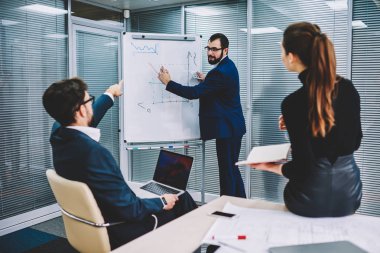 Flip grafik yanında duran ve ortakları için grafik çizim gözlük akıllı executive CEO'su sakallı. Erkek ve kadın yetenekli tüccarlar office işbirliği sırasında yeni fikirler tartışıyor