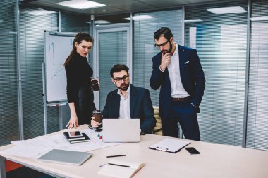 Yararlı bilgiler web sitesinde modern ofisinde oturum beyin fırtınası sırasında Internet'e bağlı dizüstü bilgisayar arama formal giyim grup yetenekli durulması hesap tüccarların giymiş