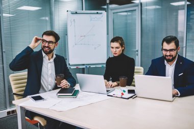 Grup olumlu deneyimli mimar dizüstü bilgisayarlar için wifi bağlı web sitelerinde araştırmalar yapma resmi elbise giymiş. Birlikte ofisinde çalışan yetenekli erkek ve kadın işçilerin