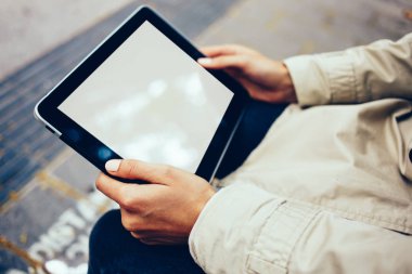 Boş ekran alanı için internet sitesi kadının elinde ile modern dokunmatik yüzey görünümünü kırpılmış. Hippi kız dijital tablet ile kopya alanı göstermek için açık havada oturma reklam holding