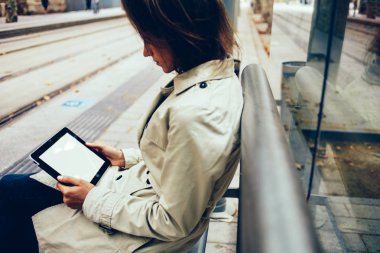 Dalgın genç kadın tramvay Caddesi üzerinde oturan e-kitap okuma yan görünüm. Hippi kız modern Dokunmatik ped cihaz eğitsel izlerken bağlı 4 g için sahte web siteniz için alanı ile internet