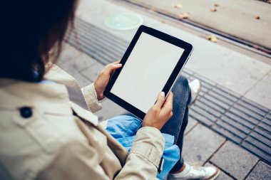 Genç kadının kırpılmış görünümünü holding dijital tablet cihaz sahte ekran üzerinde alanı ile Web sitenizin içeriği için eller. Hippi kız alan boş ekran üzerinde reklam ile modern dokunmatik yüzey ile