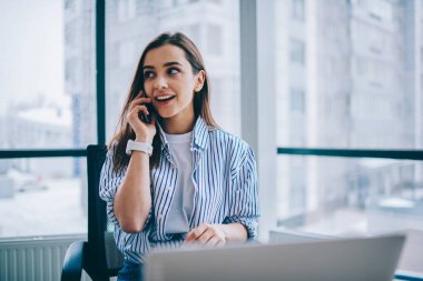Gülümseyen kadın serbest meslek sahibi İşletme ile ilgili paylaşım iyi haberler için meslektaşım arama telefon konuşmayı dizüstü ofis, yakın çalışma evinde oturan rahat kıyafet neşeli genç kadın