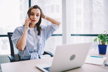 Dizüstü bilgisayarda Office, ciddi kadın serbest meslek sahibi online işletme hakkında telefon konuşma konsantre için müşteri desteği güncelleştirmesi yazılım işlecini çağırmak dalgın genç kadın