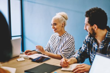 Meslektaşları ile işbirliği ve çalışma işlemi ofiste tabloda, beyin fırtınası toplantısı sırasında gülüyor neşeli kadın Tasarımcısı. Olumlu gençlerin fikirleri tartışmak akıllı rahat kıyafet