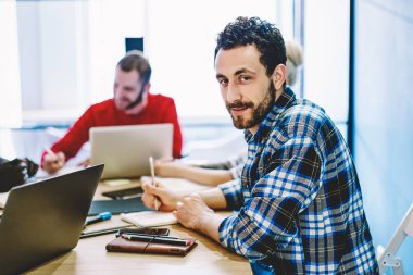 Genç adam portresi ise toplantı masada oturan ve office çalışma sürecinde tartışmaya kameraya bakarak rahat kıyafet giymiş. Dersler eğitim sırasında yakışıklı hipster öğrenci