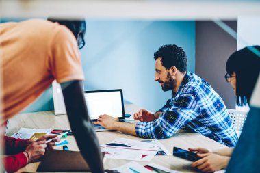 Çok kültürlü bir grup genç insan birbirleri ile modern ofiste işbirliği sırasında sunum online boş ekran alanı modern dizüstü cihaz üzerindeki izlerken akıllı rahat kıyafet giymiş