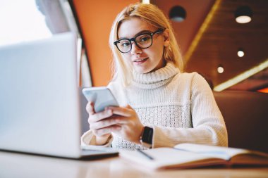 Sohbet için smartphone kafe Ardiles uzaktan laptop compute kullanarak online iş projede çalışan gözlük sevimli kadın eğitim ağlar iken tutan genç kız öğrencinin portresi