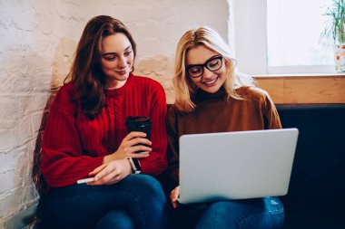 Dizüstü bilgisayar yolu ile birlikte netbook video izleme alanı coworking istirahat olumlu en iyi arkadaşlar online alışveriş yapma web sayfalarındaki çoklu ortam içeriği ile ilgilenen hippi kız gülümseyerek