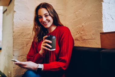 Rekreasyon smartphone, hippi kız hücresel ve wifi kullanarak sonu harcama kahve fincanı tutan kameraya gülümseyen sohbet office coworking içinde neşeli genç kadın portresi memnun