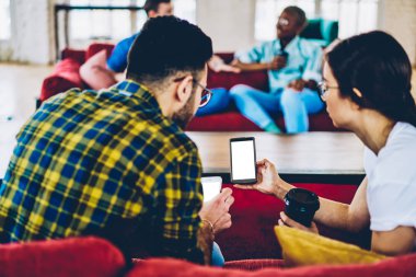 Arkadan görünüm rahat giyinmiş genç insanların blog internet reklamı için boş ekran ile modern smartphone üzerinde yaşamak akarsu izlerken kırpılmış. Arkadaşlar 4 g bağlantısı'nı kullanarak Web sitesi haber okuma