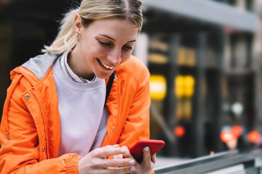 Genç erkek şehir sokak üzerinde duran cep telefonu veri Internet bağlantısı kullanarak görünümünü kapatın. Mutlu gülümseyen beyaz hippi kız sohbet etmek kullanma Smartphone cep telefonu ile kısa mesajla okuma