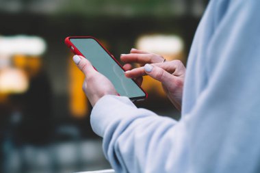 Cep telefonu uygulamaları ile internet bağlantısı kullanan kadın görünümünü kırpılmış. Erkek modern smartphone üzerinde şehir sokak tutan eller. Sosyal ağ içerik, internet trafik verileri. Ücretsiz kablosuz 