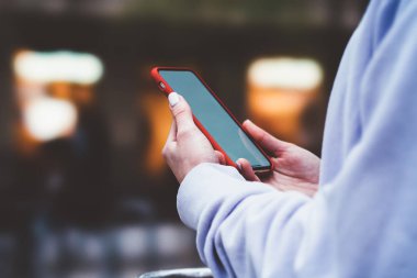 Cep telefonu uygulamaları ile internet bağlantısı kullanan kadın görünümünü kırpılmış. Erkek modern smartphone üzerinde şehir sokak tutan eller. Sosyal ağ içerik, internet trafik verileri. Ücretsiz kablosuz 