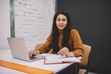 Hippi kız Üniversite Kampus ile wifi ve dizüstü bilgisayar, çalışma yayın ağları için oluşturma işlemi sırasında kameraya bakarak yetenekli kadın serbest meslek eğitim gülümseyen portresi