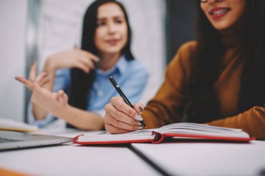 Genç kız öğrencinin not defteri bilgileri arkadaşlarıyla konuşurken süre yazma tarih seçici odak arka plan notları öğrenme sürecinde arkadaşıyla sırasında yapma kadın resim kırpılmış, bulanık