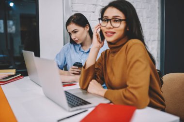 Kız öğrencinin eğitimi arkadaşına görevlerini üzerinde konsantre office birlikte oturan genç kadın danışmanlık için arama kolej sırasında arka plan üstünde laptop üzerinden izlerken tarih seçici odak