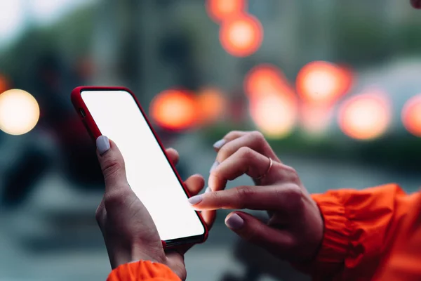 女人的手拿着大拷贝空间触摸屏的手机在户外与晚上散景城市的背景灯光 使用智能手机应用程序进行网上购物的女性特写视图 — 图库照片