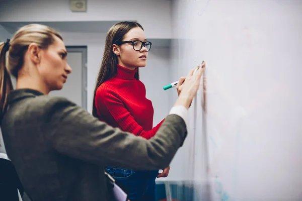 Female Colleagues Standing Flip Chart Discussing Strategy Ideas Brainstorming Session — Stock Photo, Image