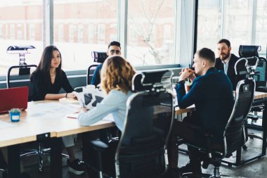 İş toplantısı'nın genç erkek ve kadın girişimcilerin modern ofis iç formal giyim giyinmiş. Masa toplantısında finans şirketi içinde gurur ceo ile Toplantı oturan çalışanlar