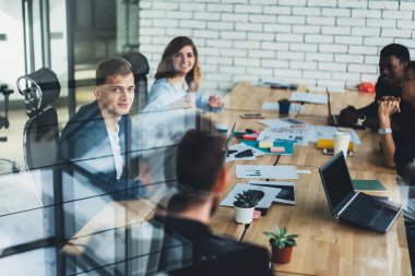 İşbirliği süreci genç yaratıcı erkek ve kadın çok kültürlü çalışanların ofis cam duvarın arkasında. Brifing sırasında başlangıç geliştirme başarılı strateji tartışmaya profesyonel tasarımcılar