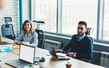 Başarılı iş ortakları portresi proje geliştirme ekip çalışması sırasında kameraya gülümseyen formal giyim giymiş. Modern ofis konferans sırasında tablo toplantı oturma pozitif çalışanlar
