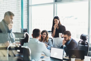 Modern ofis sonra toplantı sırasında strateji ve çözüm çalışma sürecinin tartışılması formal giyim erkek ve dişi profesyonellerin çok kültürlü takım giymiş. Gençler proje üzerinde işbirliği