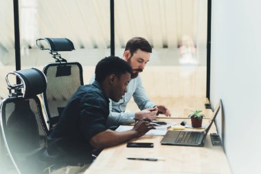 Afrika kökenli Amerikalı öğrenci ile nitelikli öğretmen özel ders ile kablosuz internet dizüstü bilgisayar başında oturan sırasında eğitim proje tartışıyor. Office çözüm üzerinde iki arkadaşları teamworking