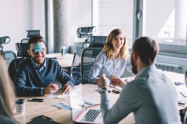Genç adamla neşeli: etiket üzerinde brifing toplantı molası sırasında eğlenmek office.positive kadın ve erkek meslektaşları sahip tasarım projesi için yaratıcı fikirler tartışılması sırasında gülen yüz