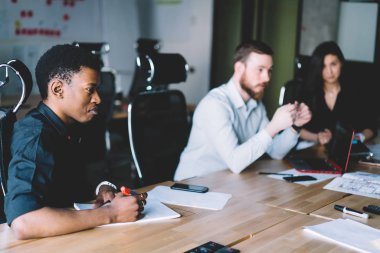 Formal giyim iş karşılaşma içinde modern ofis sırasında proje geliştirmek için fikirleri tartışmak çeşitli gençlerin takım giymiş. Çok kültürlü çalışanları verimli çözüm üzerinde işbirliği yapma