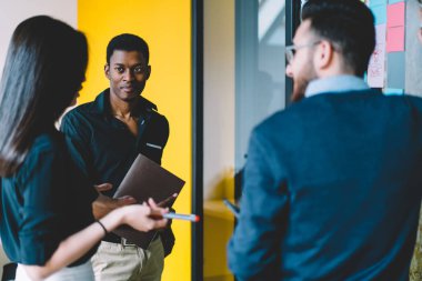 Gençlerin çeşitli takım ofiste formal giyim tartışma üretken strateji işbirliği ortak proje ayakta üzerinde giymiş. Çalışma programı hakkında konuşmak çok kültürlü iş arkadaşları