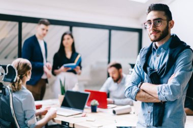Gözlük kamera arka plan projede birlikte çalışma arkadaşları süre bakarak kendine güvenen genç erkek girişimci portresi. Başarılı gurur CEO'su çapraz elle kendi iş geliştirme