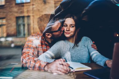 Mutlu genç çift boş zamanlarında dizüstü bilgisayarınızdaki ortak fotoğrafları izlerken seviyorum. Bakım genç adam öpüşme kız yolu ile 4g netbook üzerinde web sitelerinde arama bilgi yardım ederken internet