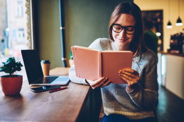 Alan, rahat giyim bestseller boş zamanlarında zevk gülen genç kadın coworking içinde seminer eğitimi için ders kitabı hazırlarken ilginç bilgi okuma Eyewear mutlu yetenekli öğrenci