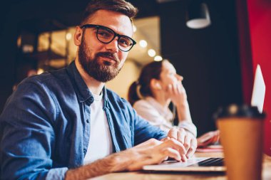 Yarım uzunluk portre pozitif geliştirici sakallı şık Eyewear USB'yi dijital dizüstü bilgisayarda kablosuz yüksek olarak bağlıyken kameraya seyir vizyon düzeltme için hızlı internet