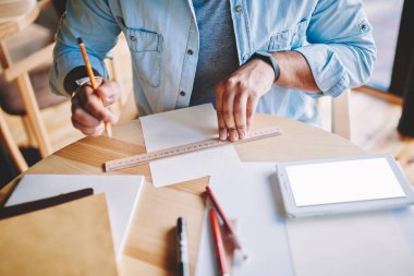 Erkek mimar skeçler dijital tablet boş kopya alanı ekran reklam bilgin içerik ile yakın çizmek için kalem ve kural kullanarak trendy denim kıyafeti giymiş resim kırpılmış