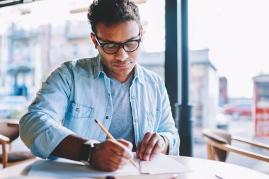 Profesyonel hindu tasarımcı el alan coworking içinde serbest çalışma kroki çizim kalem ile konsantre. Dalgın yaratıcı erkek mimar cetvel planı oluşturmak için kullanarak
