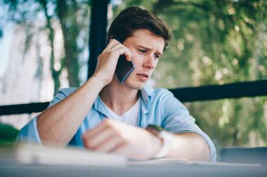 Hayal kırıklığına uğramış genç 20 yıl smartphone aygıt üzerindeki telefon görüşmesi sırasında eski kötü haber kafa ile mutsuz adam. Üzgün hipster adam cep üzerinde problem çözme hakkında konuşurken rahat kıyafet giymiş